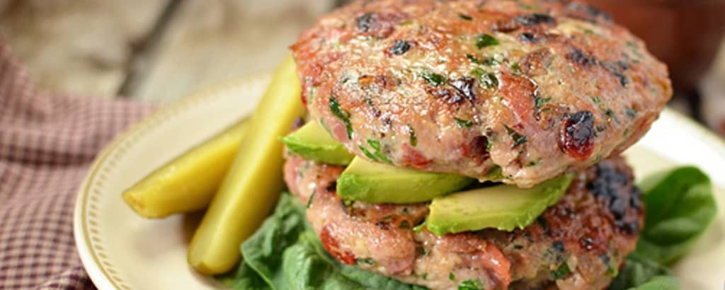 A stack of moist and flavorful prosciutto, olive, and sun-dried tomato turkey patties.